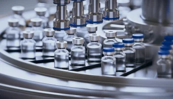 Closeup of ampules are being filled with vaccine and closed with blue caps. Medical wallpaper